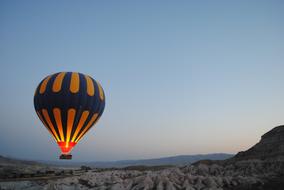 Colorful hot air balloon, with the light, above the beautiful landscape, at colorful and beautiful sunset
