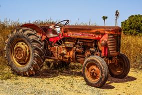 old rusty tractor on a field on a sunny day