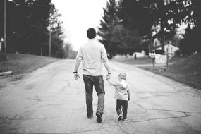 man with a child on the road in black and white background