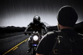 photo of a motorcyclist on a highway in the rain