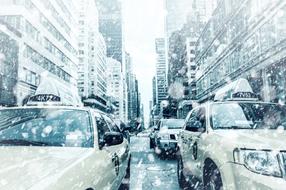 a taxi on a street in New York under snow