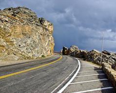 Beautiful road among the rocks, under cloudy sky, in Colorado, USA