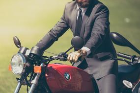 man in a business suit on a motorcycle on a blurred background
