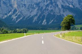 photo of a flat highway against the background of the Alps