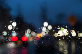 colorful lights in night city through wet glass, bokeh