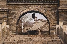 view of old Small Town through arch in brick wall