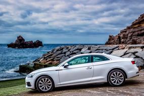 white car on the beach on a cloudy day
