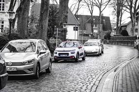 parked cars on a narrow city street in monochrome