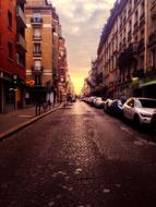 Beautiful landscape of the road with cars in Paris, France, at colorful sunset on horizon