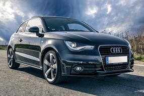 Audi, new Black Auto beneath dramatic sky