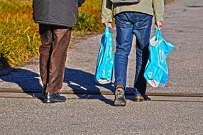 two people carry packages in their hands from the store