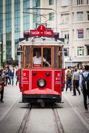 Beautiful, red, vintage tram, among the people, on the Taksim Square in Ä°stanbul, Turkey