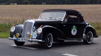 Mercedes Benz 220 Cabriolet on the road near the field