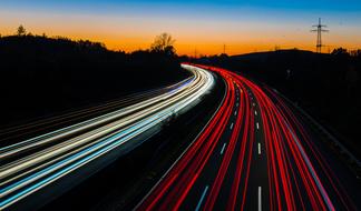 red and white light stripes on a highway bend