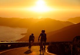 cyclists at sunset on the mountain road