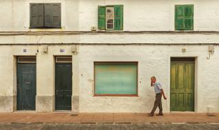 man with phone near old house