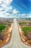 panoramic photo of a highway in the desert against a blue sky