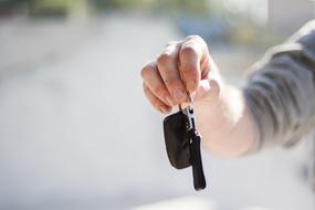 car keys in hand on blurred background