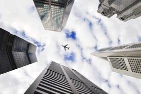 plane flies over city skyscrapers