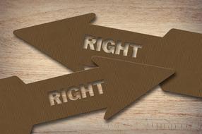 cardboard right arrows on the wooden surface