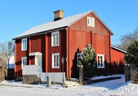winter photo of a two-story cottage in Sweden
