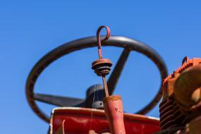 closeup photo of black steering wheel of a red tractor