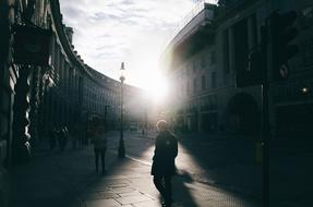 people on city street at sunset, UK