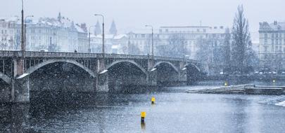 Beautiful bridge and buildings, among the tees in the beautiful Prague, Czech Republic, in the snow, in the winter