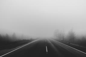 monochrome photo of mystic fog over highway