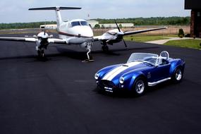aircraft and AC Cobra sports car on the runway