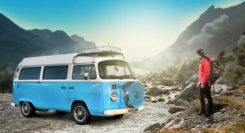 traveler and retro volkswagen bus in the mountains
