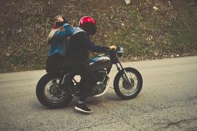 couple with helmets on a motorcycle