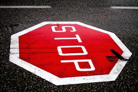 painted red stop sign on the highway road