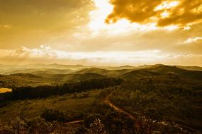 Beautiful landscape of the mountains with the forest, at colorful sunrise among the clouds