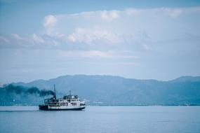 Beautiful landscape with the cruise ship near the shore with mountains