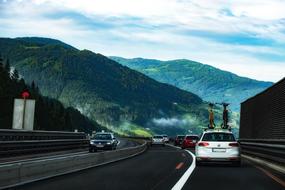 cars on the highway against the backdrop of foggy alpine mountains