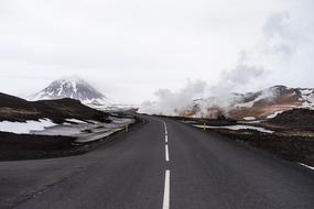 panorama of a flat highway to the snowy mountains