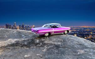 purple chevrolet impala on a rock in the background of night panorama of Las Vegas