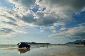 photo of a jeep and tourists on the beach