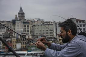 photo of a fisherman on the promenade in the city