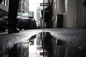 reflection of the facades of city buildings in a puddle