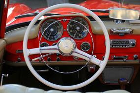 White steering wheel and dashboard of the red Mercedes car in the museum