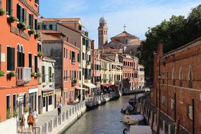 tourists walk along the canal in Venice, Italy