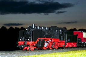 red-black steam locomotive against the background of the night sky