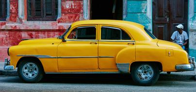 old yellow car parked on city street