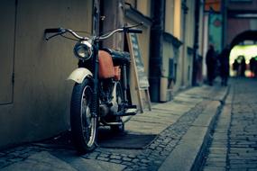 motorcycle stands on the sidewalk at night