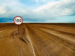 speed limit sign on a sandy road