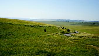 panorama of green meadow and stream in the countryside