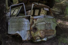forgetting a rusty broken car in a forest