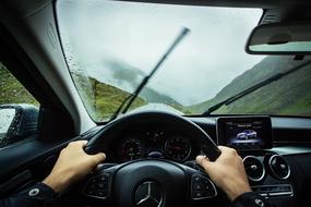 hands on the wheel of a mercedes benz car